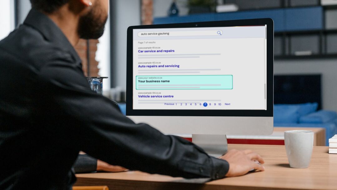 Man at a desktop computer looking at page 7 of the search results for auto service gauteng, with one business listing highlighted